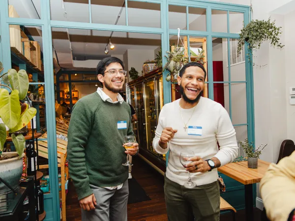 Two members of Colado Latino Network laughing together at an event