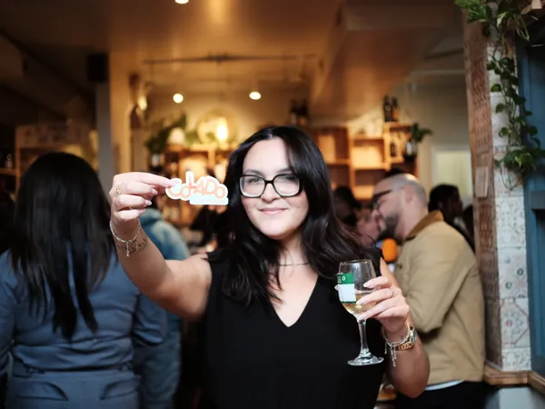 Community member holding a Colado sticker at a Baltimore networking event