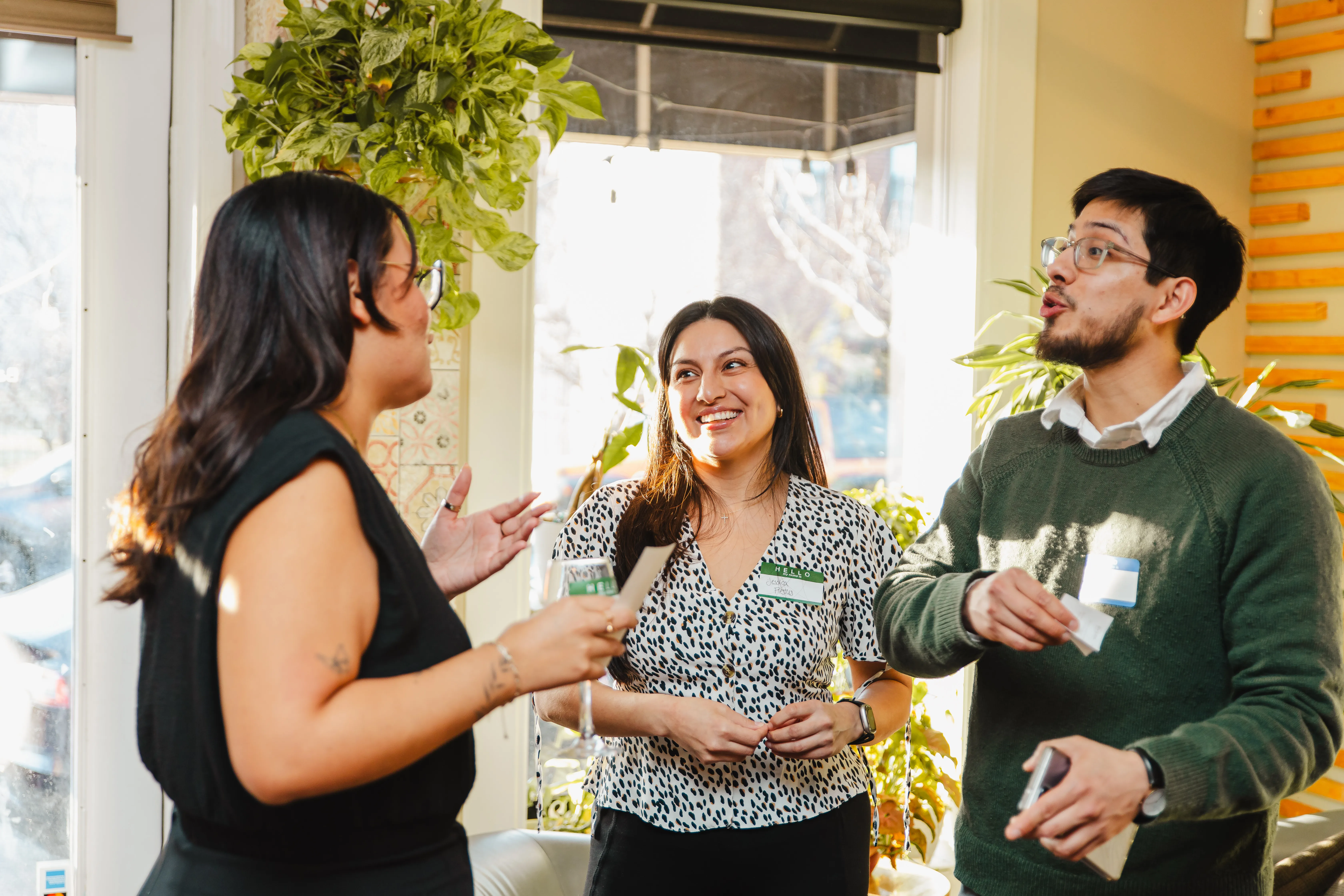 Three people smiling and connecting at a Colado Latino Network event in Baltimore