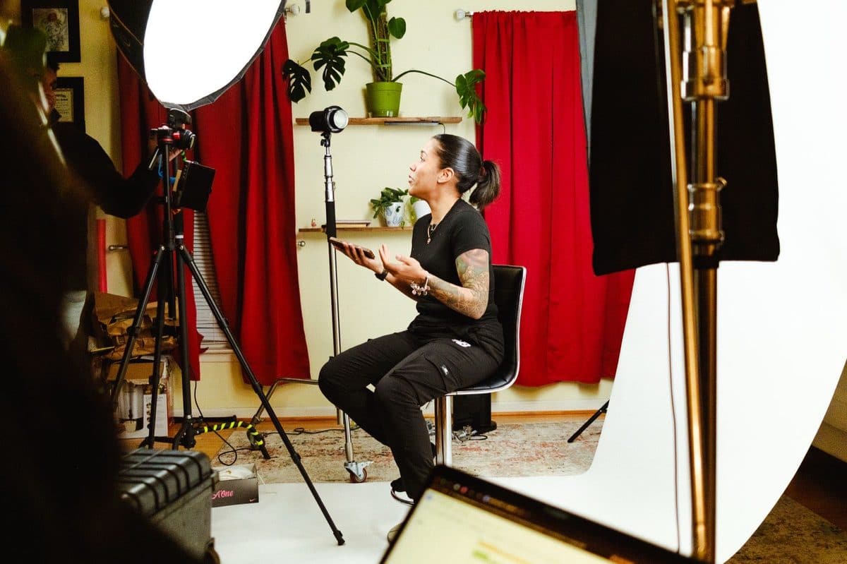 A Colado Latino Network co-founder speaking on camera during a content shoot in Baltimore, MD, surrounded by studio lights