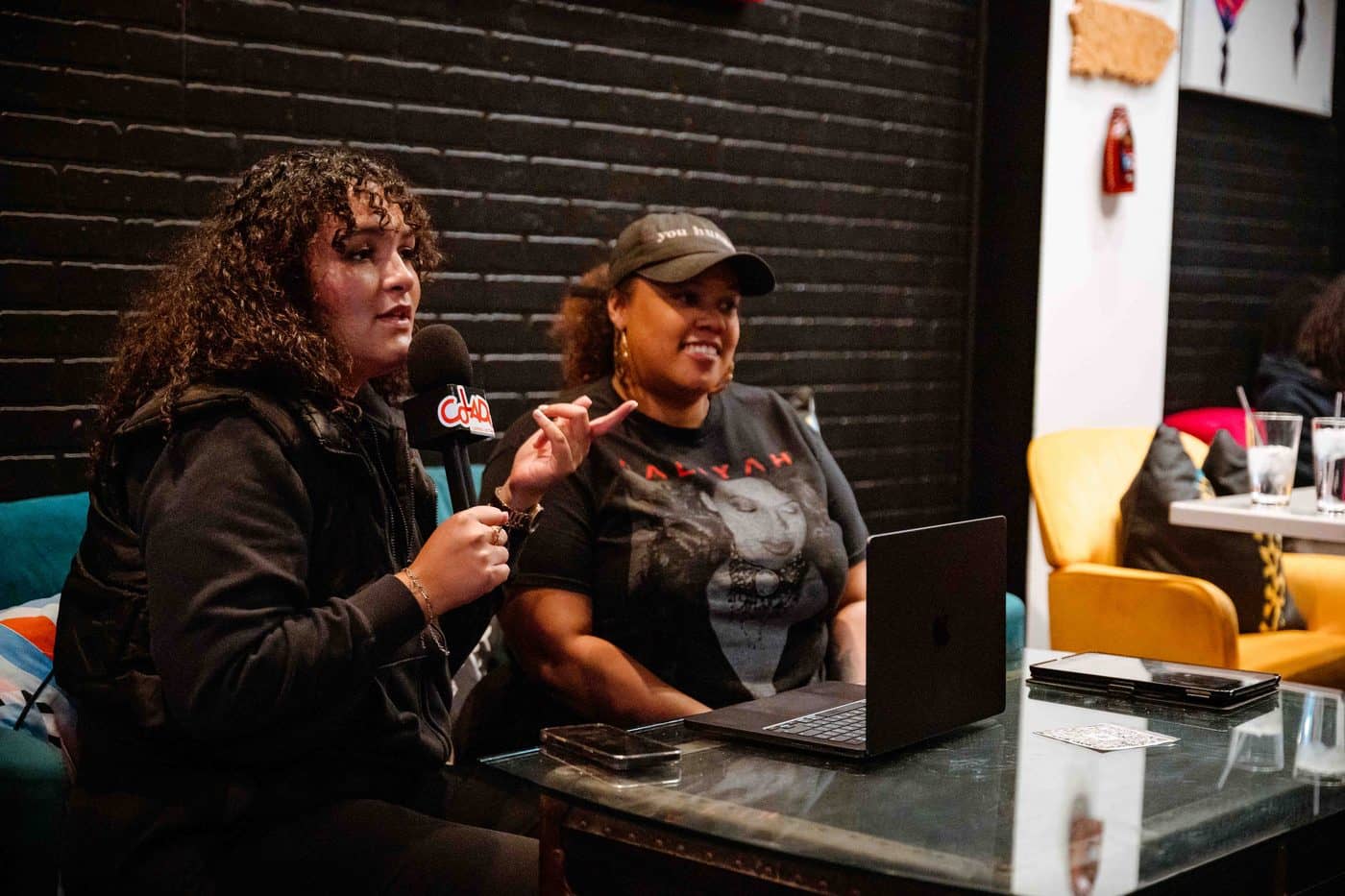Two Colado Latino Network members in conversation at a Colado event in Baltimore, MD, one holding the Colado branded microphone