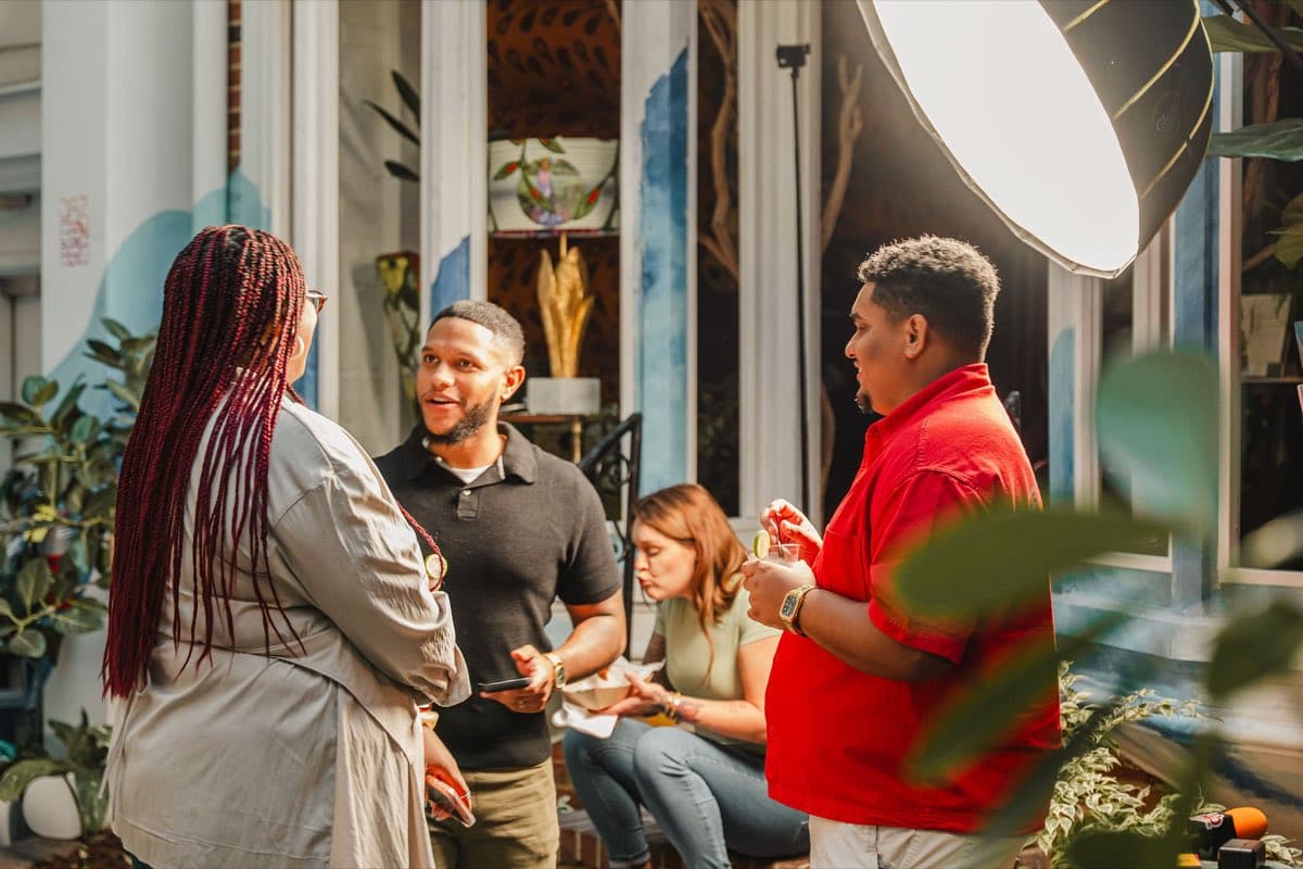 A group in conversation in the courtyard at the Colado Latino Network event at Stem & Vine in downtown Baltimore
