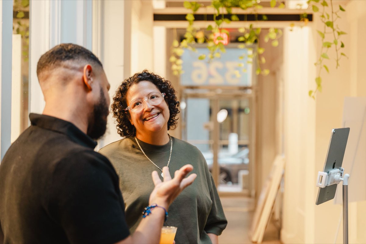 Two guests talking near the entrance at the Colado Latino Network event at Stem & Vine in downtown Baltimore